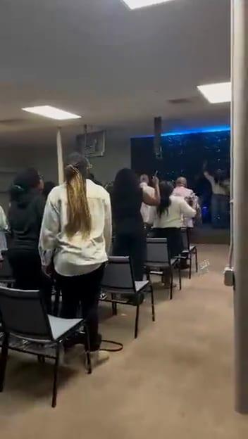 Video: the room from the aisle, people standing and singing along.