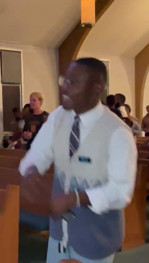 Video: a man in a white shirt and tie dances in the aisle.